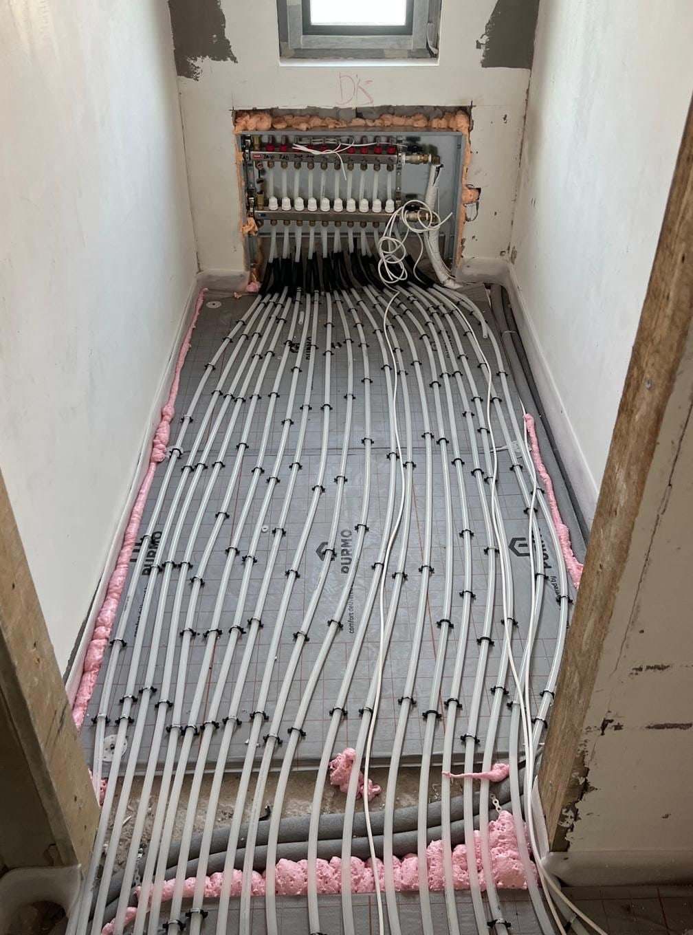 Distribuitor de încălzire în pardoseală încastrat în perete, din care pornesc circuitele