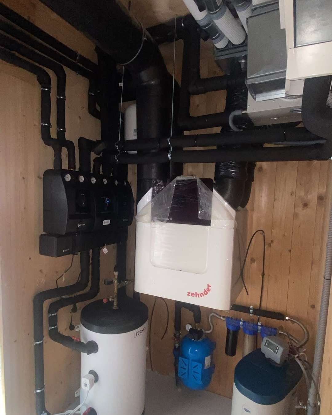 Cameră tehnică cu pereți de lemn, cu unitatea de ventilație, grupuri de pompare și boiler