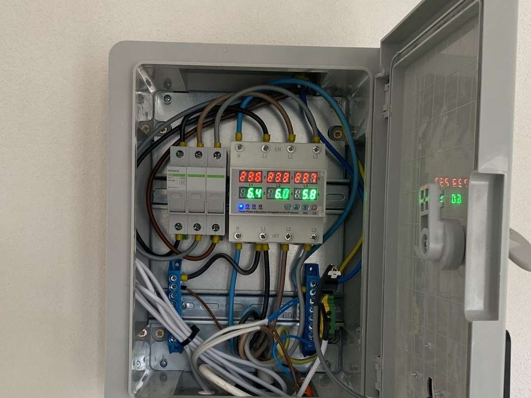 Tablou electric deschis, montat pe perete, cu siguranțe și un releu de protecție cu afișaj
