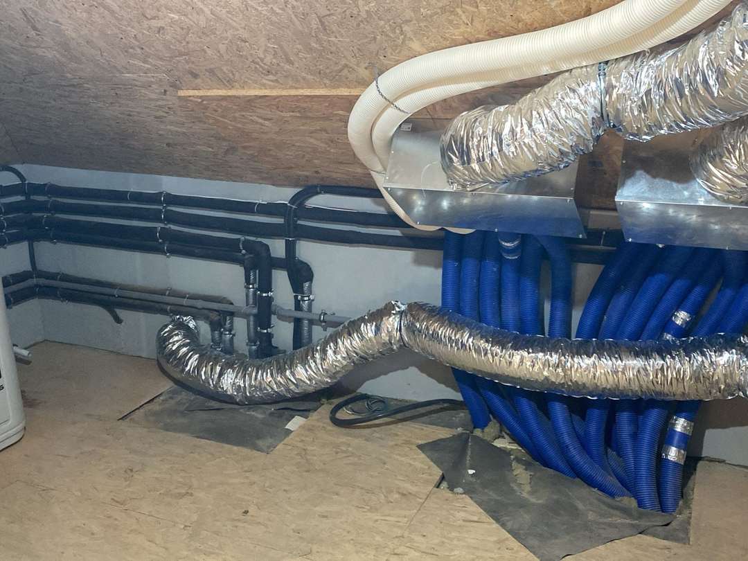 Tuburi albastre de distribuție a aerului și tuburi flexibile de aluminiu într-un pod