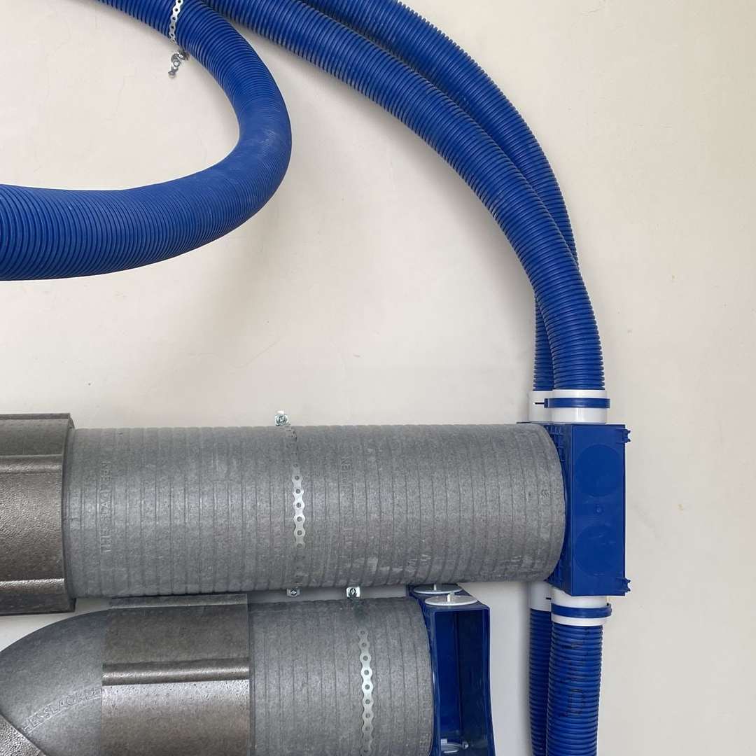 Tuburi flexibile albastre de ventilație și conducte izolate gri racordate la distribuitoare